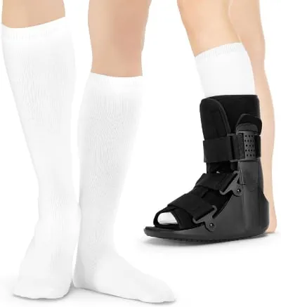 Tall white sock liners, one worn under a black cam walking boot